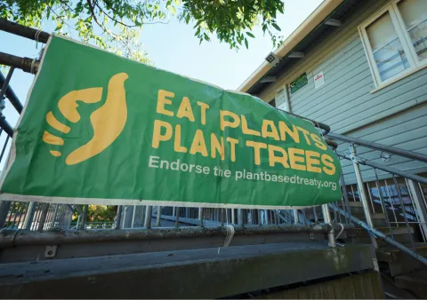 Eat Plants Plant Trees banner outside A4A Forum 2025